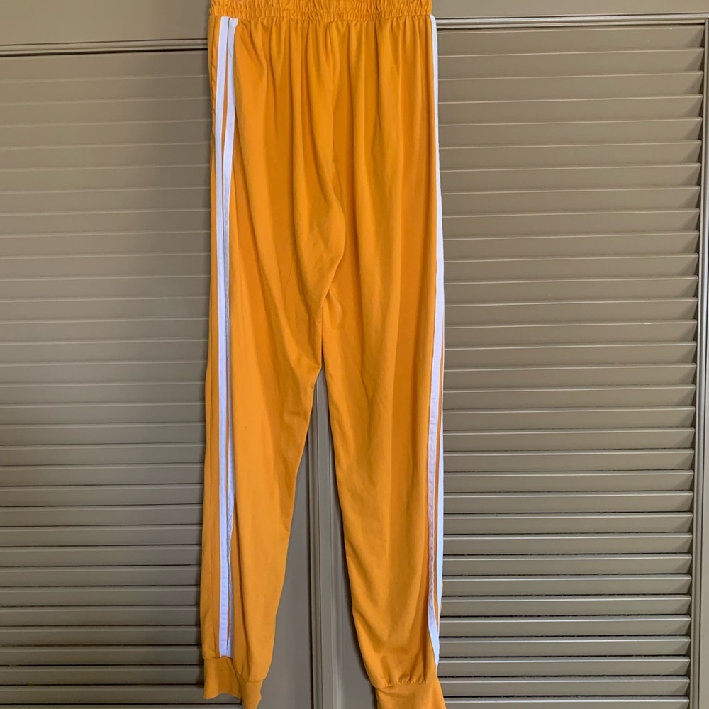 Yellow and white striped jogging pants with pockets. Size S